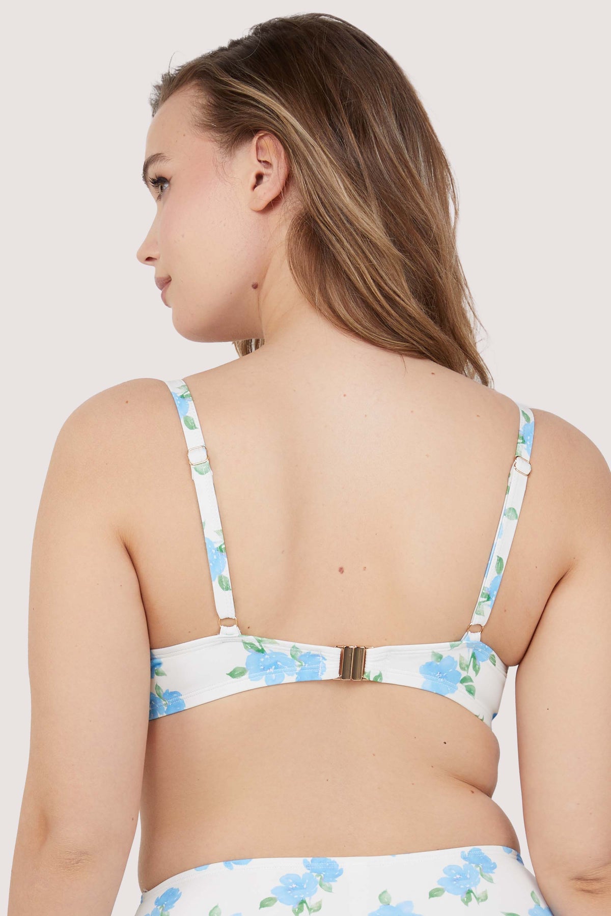 Model shows adjustable shoulder straps and clip fastening back of floral bikini top