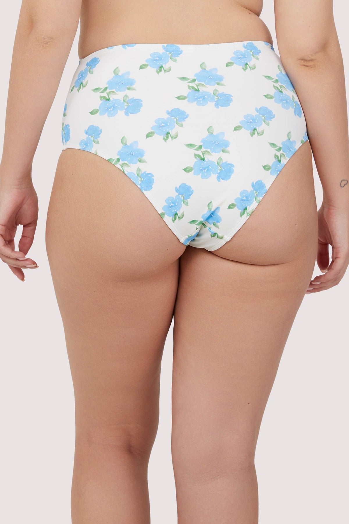 Model shows full brief of blue floral high waist bikini bottom