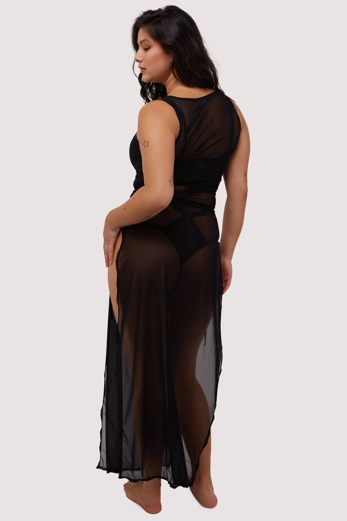 Model wears sexy sheer black mesh long dress with deep side splits